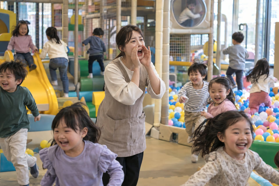 시끄러운 키즈카페에서 직원이 두 손을 입에 모으고 크게 외치는데 아이들이 뛰어노는 모습